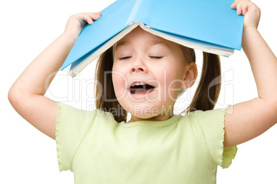 Cute little girl plays with book