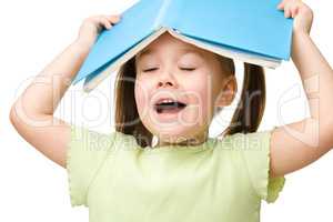 Cute little girl plays with book