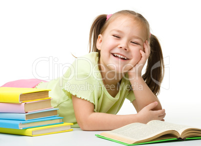 Cute little girl reads a book