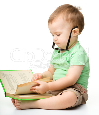 Cute little boy reads a book