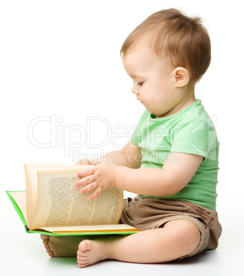 Cute little boy reads a book