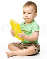 Cute little boy reads a book
