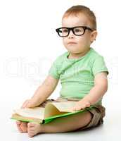 Cute little boy reads a book