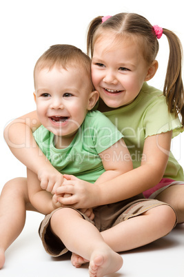 Two children are having fun while sitting on floor