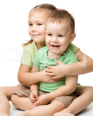 Two children are having fun while sitting on floor