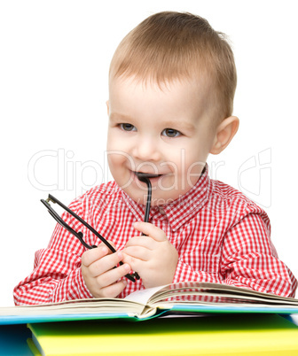 Little child play with book and glasses