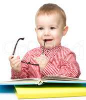 Little child play with book and glasses