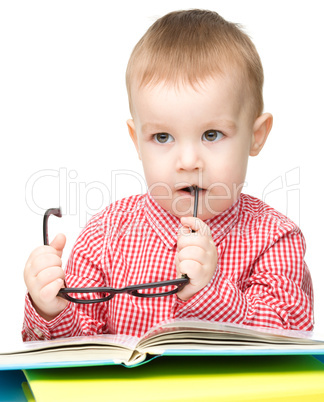 Little child play with book and glasses