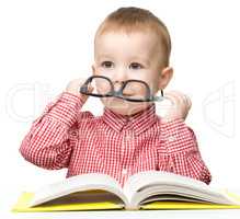 Cute little boy reads a book