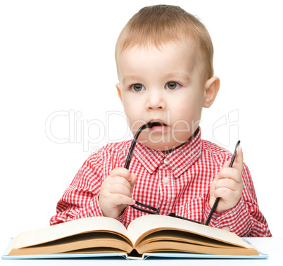 Little child play with book and glasses