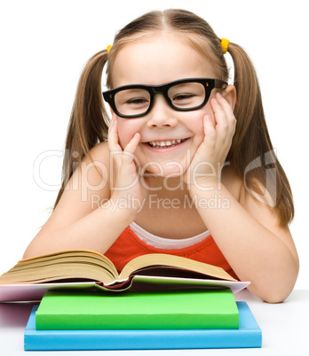 Cute little girl reads a book