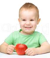 Portrait of a cute cheerful little boy with apple