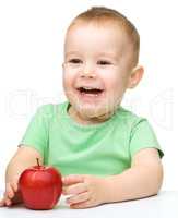 Portrait of a cute cheerful little boy with apple