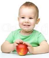 Portrait of a cute cheerful little boy with apple