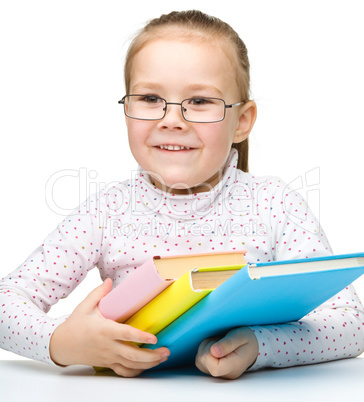 Cute cheerful little girl reading book