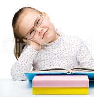 Cute little girl is tired of reading her book