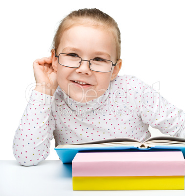 Little girl is reading a book