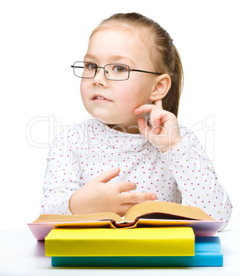 Little girl is reading a book