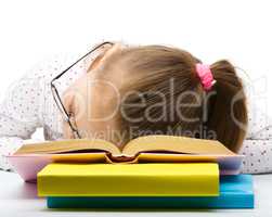 Little girl is sleeping on her books