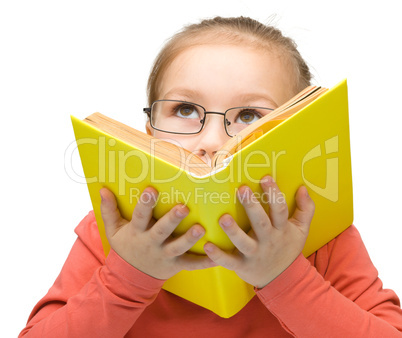 Little girl is dreaming while reading book
