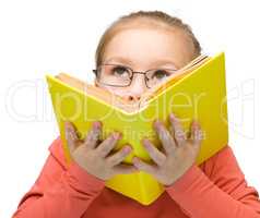 Little girl is dreaming while reading book
