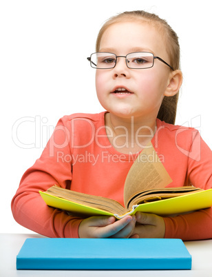 Cute little girl reading book