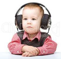 Cute little boy enjoying music using headphones