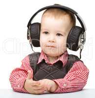 Cute little boy enjoying music using headphones