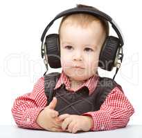 Cute little boy enjoying music using headphones