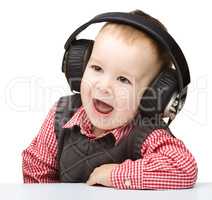 Cute little boy enjoying music using headphones