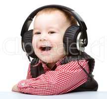 Cute little boy enjoying music using headphones