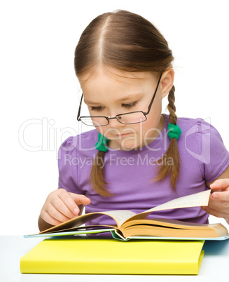 Cute little girl reading book wearing glasses