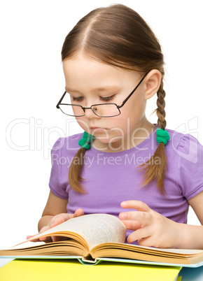 Cute little girl reading book wearing glasses