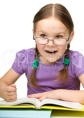 Cute little girl hits a book with fist