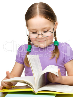 Cute little girl reading book wearing glasses