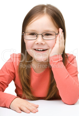 Little girl smiling while wearing glasses