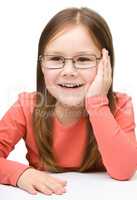 Little girl smiling while wearing glasses