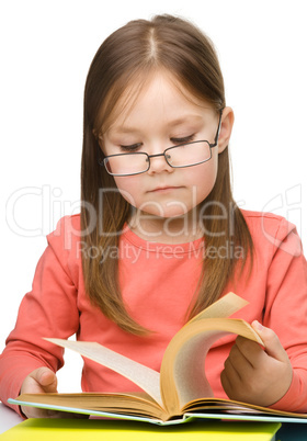 Cute little girl reading book wearing glasses