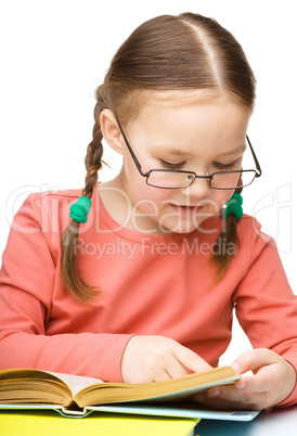 Little girl is reading a book