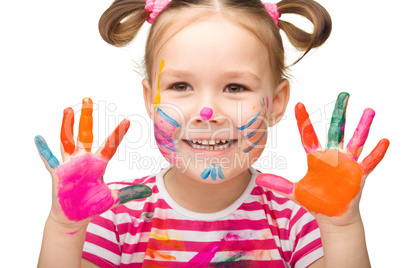 Portrait of a cute girl playing with paints