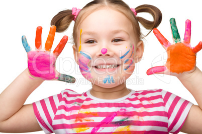 Portrait of a cute girl playing with paints