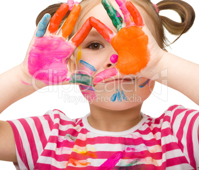 Portrait of a cute girl playing with paints