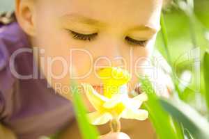 Portrait of a cute little girl smelling flower