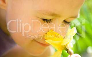 Portrait of a cute little girl smelling flowers