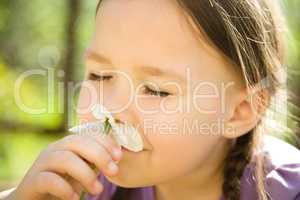 Portrait of a cute little girl smelling flowers
