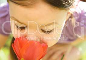 Portrait of a cute little girl smelling flowers