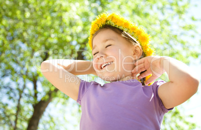 Portrait of a little girl with dandelion wreath