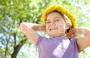 Portrait of a little girl with dandelion wreath