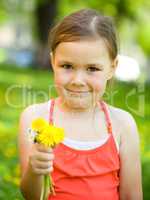 Little girl with a bunch of dandelions