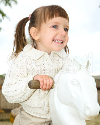 Little girl is swinging on see-saw